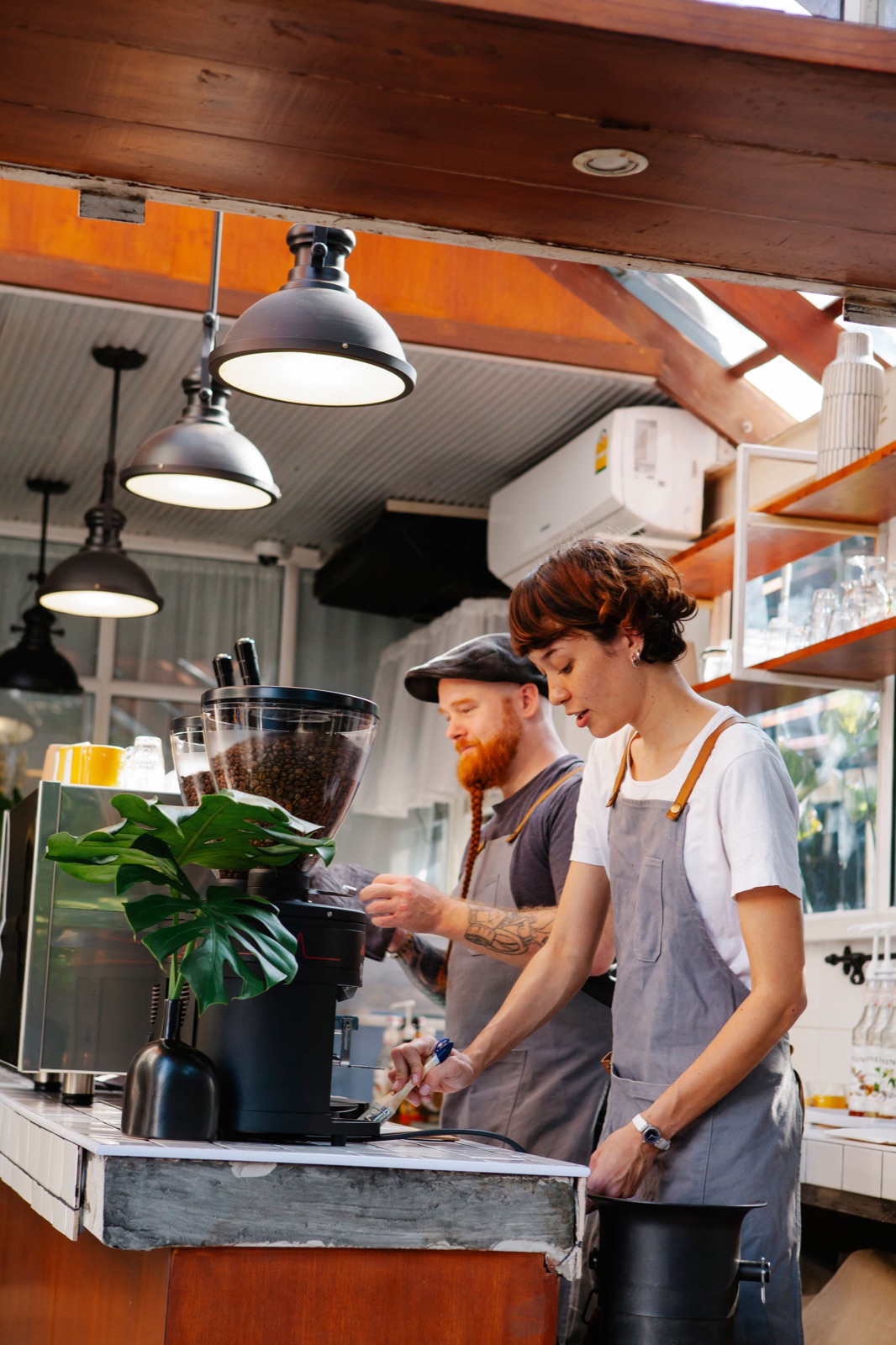 Two café workers preparing drinks behind a counter